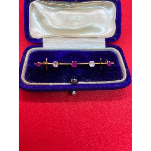 405 - A CASED GOOD BAR BROOCH SET WITH THREE GOOD BURMESE RUBIES AND TWO DIAMONDS MOUNTED IN HIGH CT GOLD