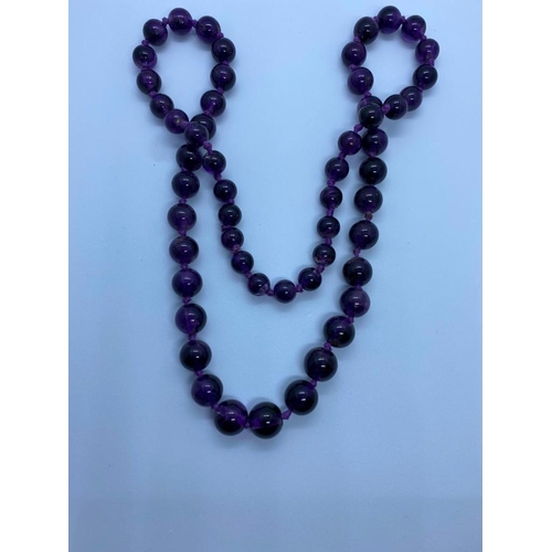 406 - A good long graduated amethyst bead necklace 64 cms length