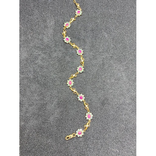 407 - AN ATTRACTIVE FANCY LINK BRACELET WITH NINE RUBY AND ALEXANDRITE CLUSTERS IN 9CT GOLD - 5.4 GMS INC ... 