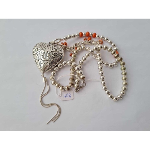 408 - A large white metal heart shaped pendant neck lace, the white metal balls interspersed with pink cor... 