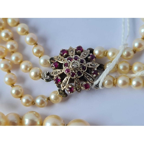 39 - A TRIPLE ROW PEARL NECKLACE WITH WHITE GOLD DIAMOND AND RUBY CLASP