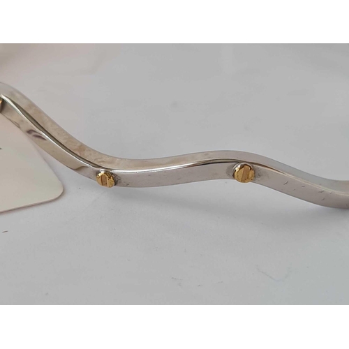 105 - A white gold designer wave hinged bangle with yellow gold bolt 9ct