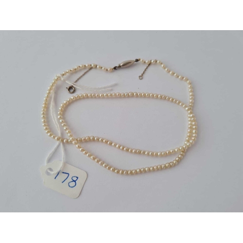 178 - A NATURAL PEARL NECKLACE WITH PLATINUM BARREL CLASP