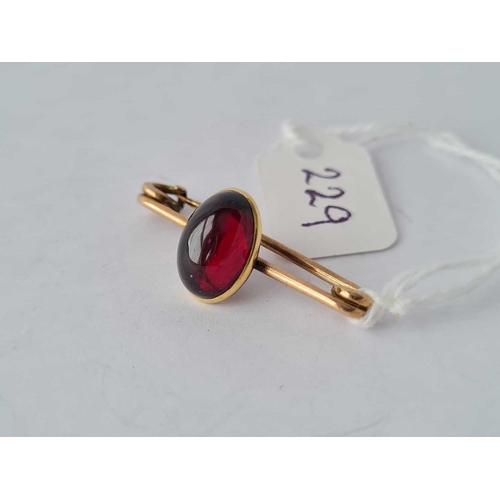 229 - A gold cabochon garnet brooch - 3.1 gms