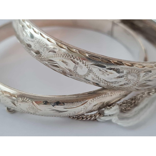 273 - Two silver scroll engraved hinged bangles 28g