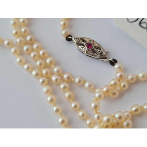 365 - A BOXED PRETTY NATURAL PEARL NECKLACE WITH 9CT WHITE GOLD AND RUBY CLASP