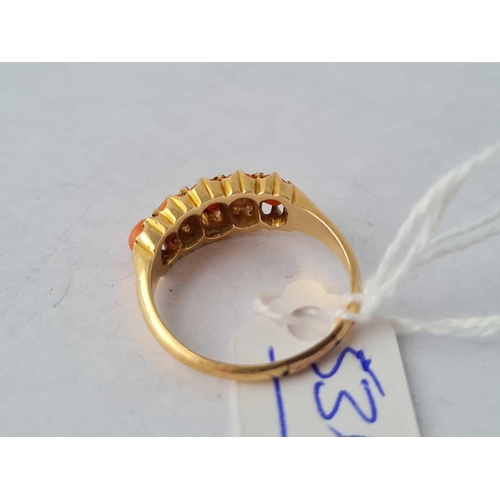 536 - A five stone coral ring 18ct gold size O - 3.6 gms