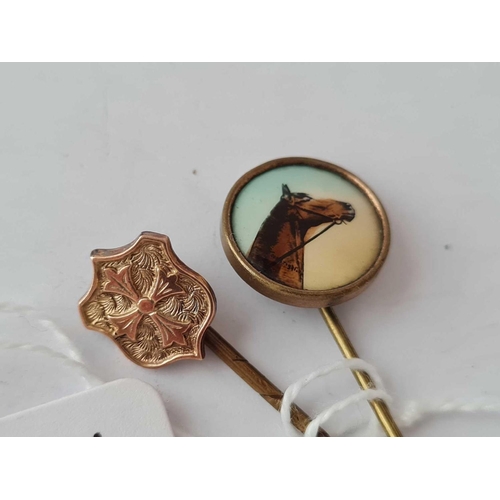 136 - A French Victorian gold armorial shield stick pin together with a racehorse stick pin