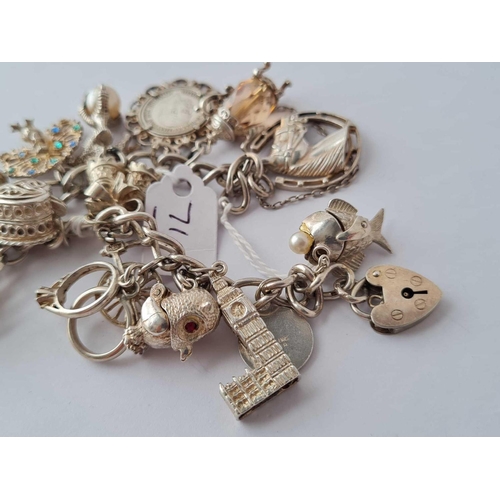 71 - A good silver charm bracelet with numerous silver charms 67g