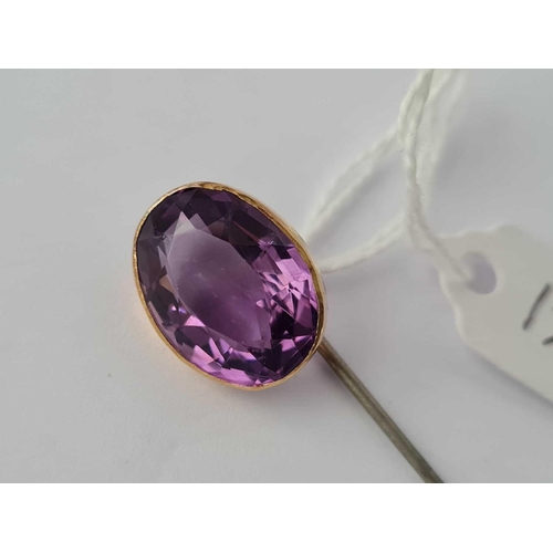 128 - A large amethyst stick pin mount set in gold, metal pin