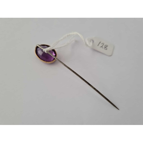 128 - A large amethyst stick pin mount set in gold, metal pin