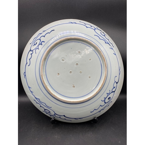 1752 - A Chinese plate painted with fish within a blue border, 14” diameter