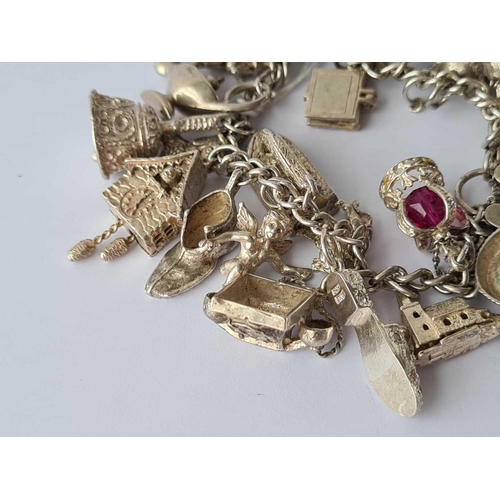 72 - A heavy silver vintage charm bracelet with 22 charms 74 4g