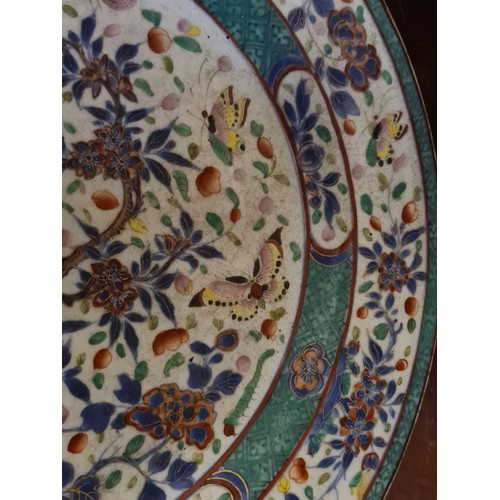 1749 - A Chinese charger enamelled with butterflies amongst flowering plant, 13” diameter