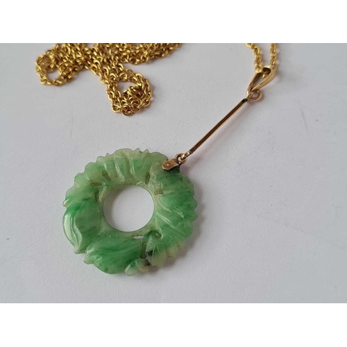 51 - An early 20th Century carved jade and gold pendant on a yellow metal chain, 16� long