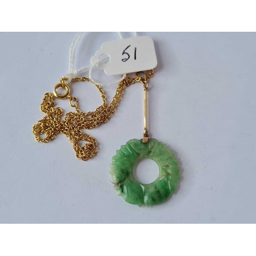 51 - An early 20th Century carved jade and gold pendant on a yellow metal chain, 16� long