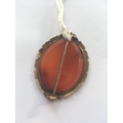 26 - A GEORGIAN GOLD BROOCH SET WITH A CARNELIAN CARVED INTAGLIO DEPICTING A GEORGIAN MAN IN A HUNTING SC... 