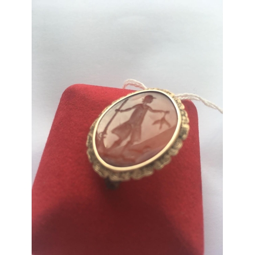 26 - A GEORGIAN GOLD BROOCH SET WITH A CARNELIAN CARVED INTAGLIO DEPICTING A GEORGIAN MAN IN A HUNTING SC... 