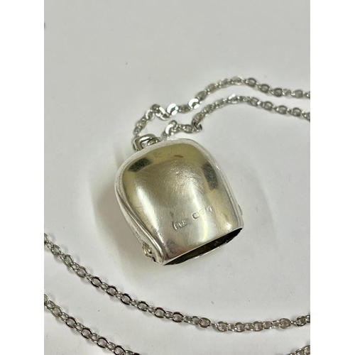 551 - A silver cow bell pendant necklace