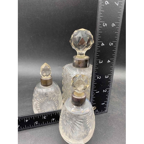 685 - Three mounted scent bottles with silver mounts and glass bodies