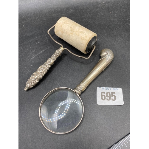 695 - A silver handled stamp roller an a magnifying glass with silver handle