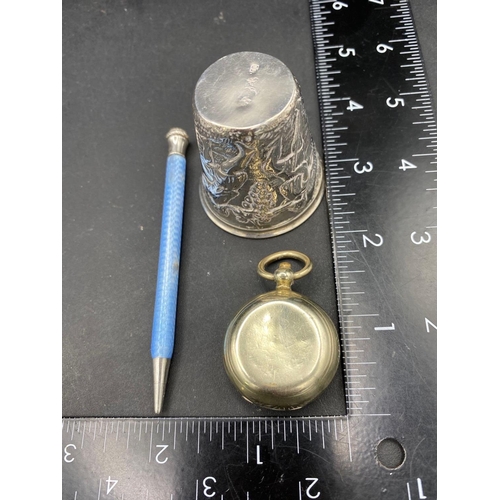 790 - A continental embossed (800 standard) beaker, an enamel decorated pencil and a plated sovereign case