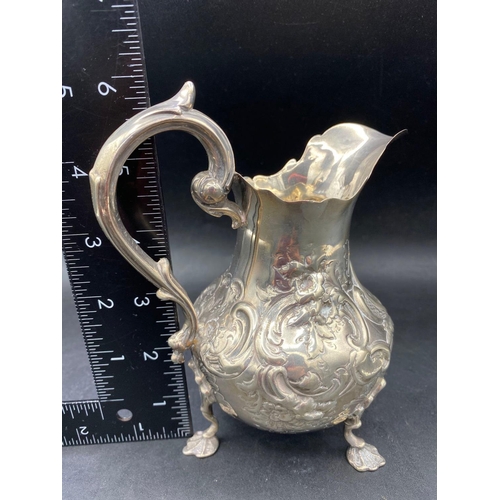 792 - A large Victorian embossed cream jug standing on shell feet, 6