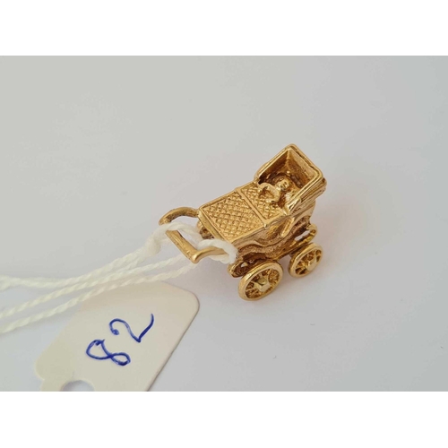 82 - A novelty charm of a baby in pram with rotating wheels 9ct   5.1 gms