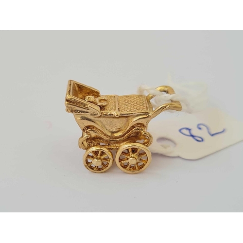 82 - A novelty charm of a baby in pram with rotating wheels 9ct   5.1 gms