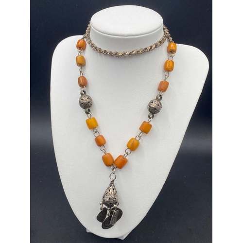 457 - A early 20th century ethnic silver and butterscotch amber necklace