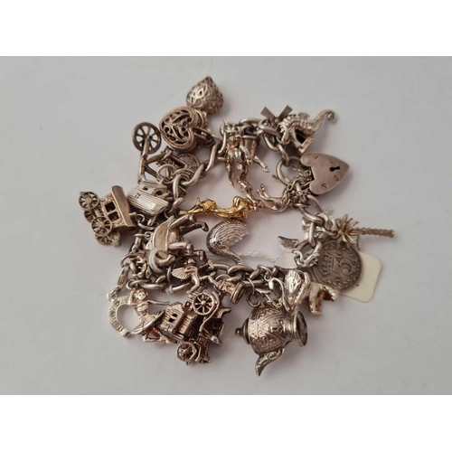 107 - A good silver charm bracelet over twenty charms   85 gms