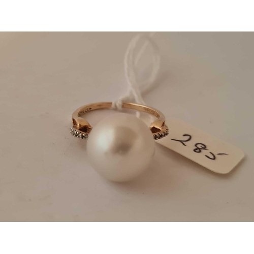 285 - A large pearl ring with diamond shoulders 10ct size O