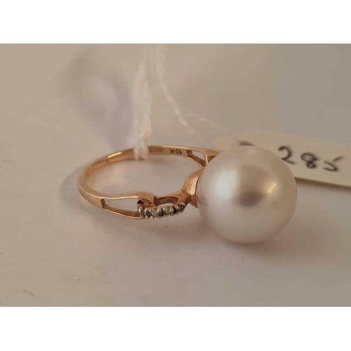 285 - A large pearl ring with diamond shoulders 10ct size O