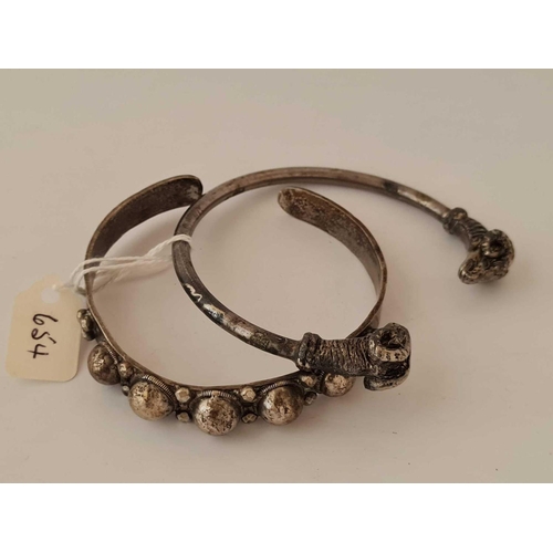 654 - Two white metal torque bangles one with rams heads ends