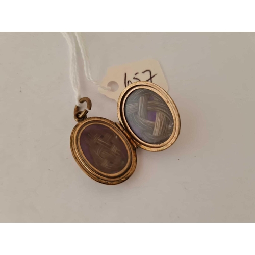 657 - A gold  back and front enamel mourning locket