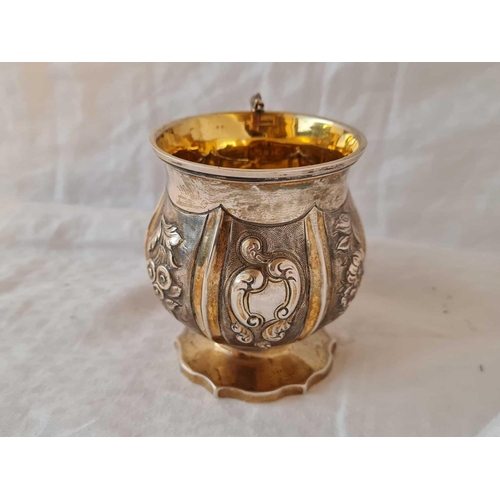 722 - A parcel gilt Georgian Christening mug with embossed panels and Lizard shape cast handle, 3.5