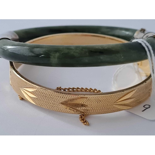 119 - A rolled gold bangle and green hard stone bangle