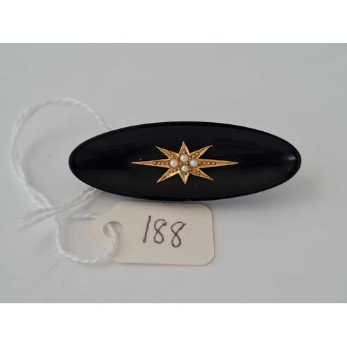 188 - A onyx brooch with pearl and gold  setting to centre