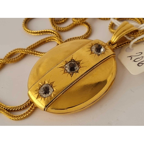 206 - A good gilt oval hinged locket set with three stones 2.5 inches on long gilt chain 32 inches