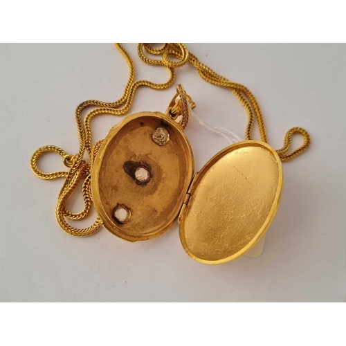 206 - A good gilt oval hinged locket set with three stones 2.5 inches on long gilt chain 32 inches