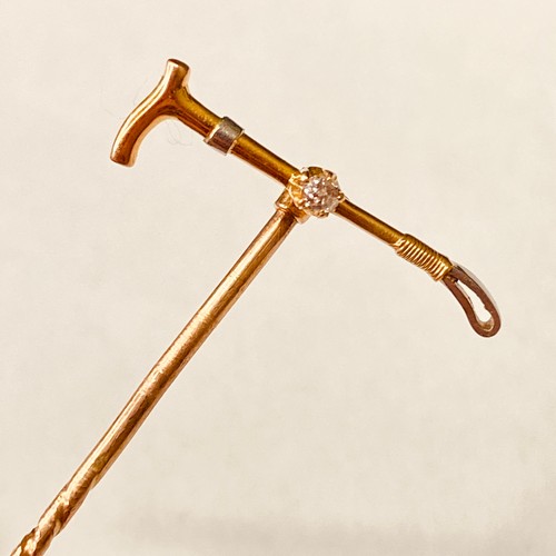 146 - A high carat gold and platinum diamond set riding crop Stick Pin