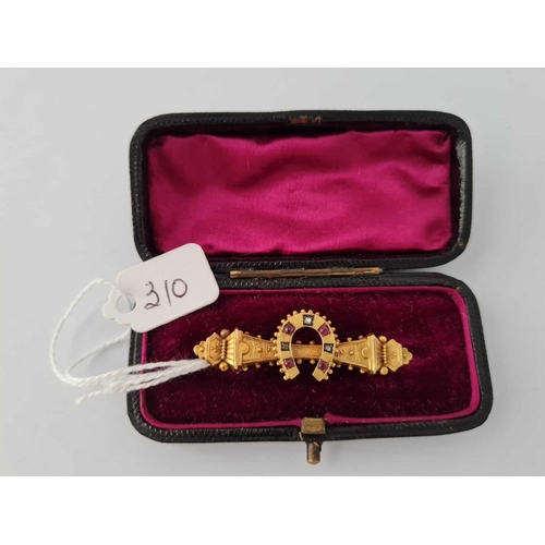 310 - A Victorian horse shoe brooch set with ruby�s and diamonds 15ct gold     3.2 gms boxed