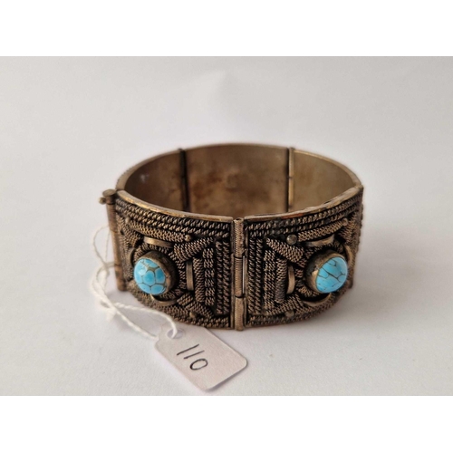 110 - A hand made five panel decorated bangle each ornate panel with central turquoise matrix bead