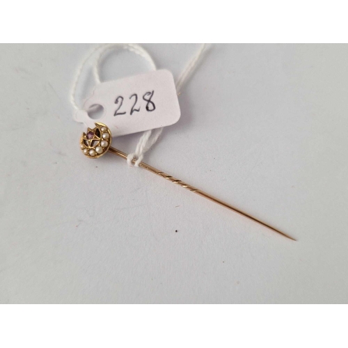 228 - A gold crescent stick pin with pearl and ruby top