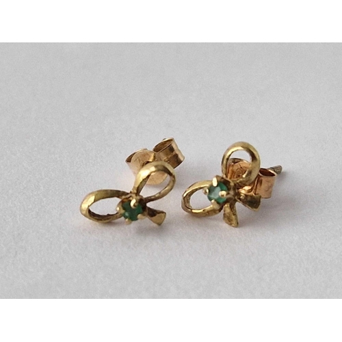 246 - A pair of emerald set bow shaped ear studs 9ct