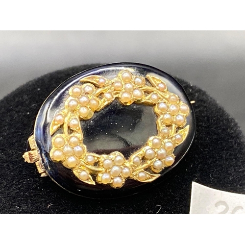 26 - A EARLY VICTORIAN REAL PEARL AND ONYX WREATH SHAPED BROOCH WITH ORIGINAL PLAITED HAIR TO REVERSE HIG... 