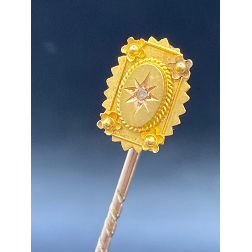 540 - A attractive diamond set topped stick pin set in 15ct gold