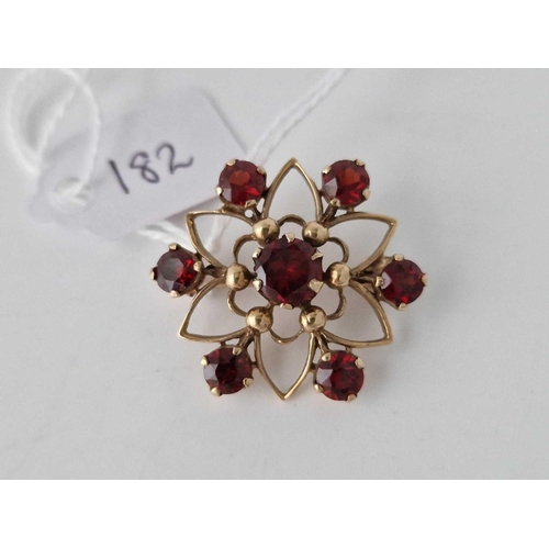 182 - A circular brooch with garnets 9ct 4.4 gms