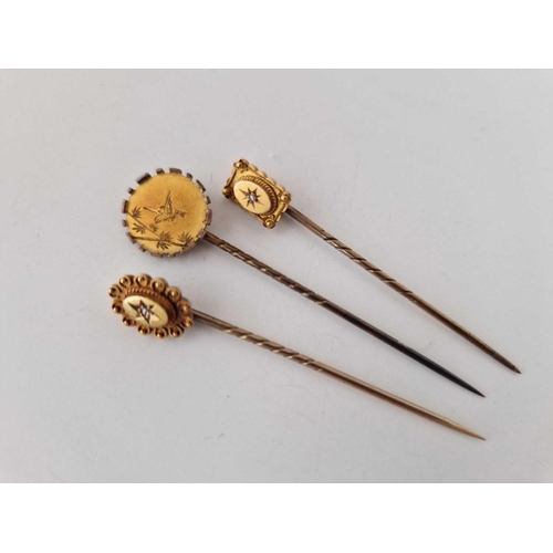 28 - Three antique gold stick pins 2 marked 15ct gold and set with a diamond and the 3 with a Japanese de... 