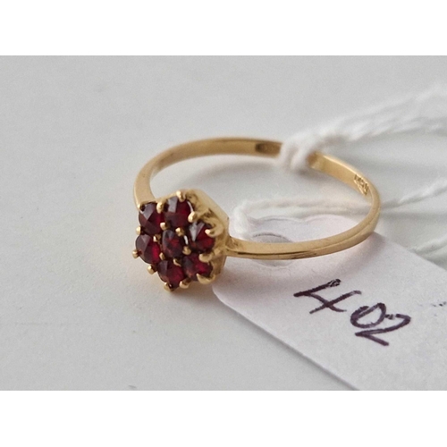 402 - A flower head design gold garnet cluster ring 18ct gold size O